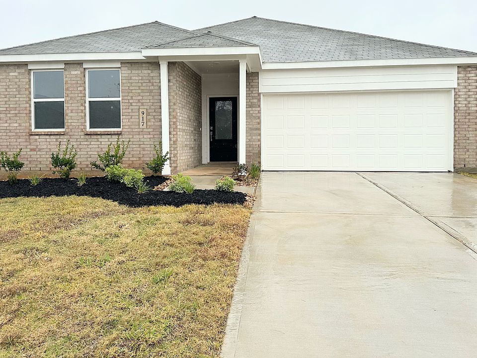 Front yard of the house showing attached 2 car garage.