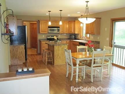 Eat-in Kitchen : Custom oak cabinets and laminate wood flooring. Sliding doors to feature deck.