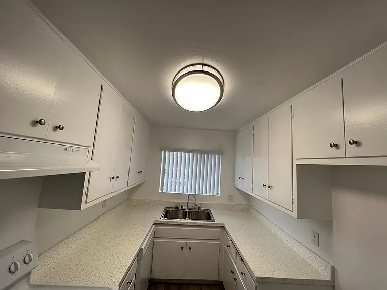 Looking toward kitchen 1x1 
Refrigerator opening on right side and electric stove on left side.