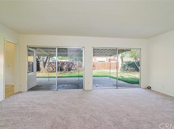 Living room view to covered patio and back yard