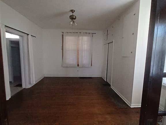Pocket doors in living room lead to big bedroom with closet and side entrance to bathroom