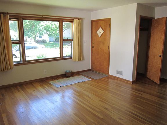Large, sunny living room with picture window and wood floor