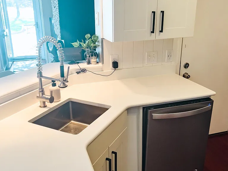 White soft close kitchen cabinets, updated hardware and stainless steel appliances.