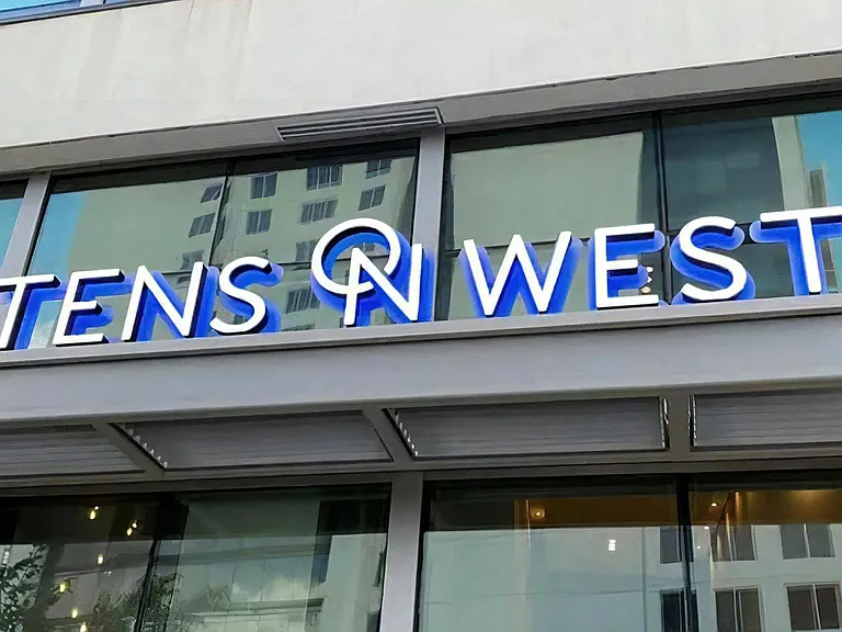 Close-Up of Tens on West Apartment Name on Glass Building Facade