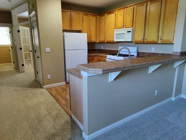 Kitchen and eating counter with plenty of cabinet space and a pantry.