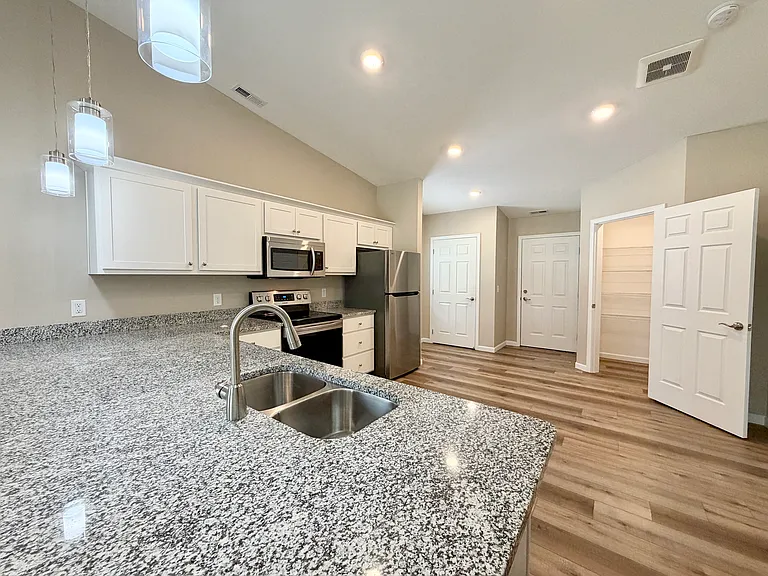 View of kitchen and walk-in pantry from the bar
