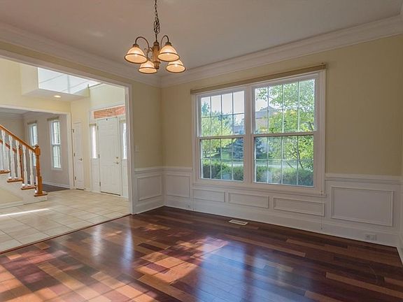 Formal dining room with gorgeous hardwood floors, wainscoting and custom crown moulding
