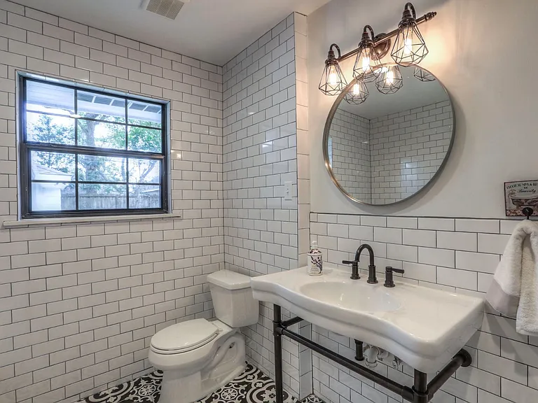 Welcome to this adorable bathroom with gorgeous tiles and pedestal sink
