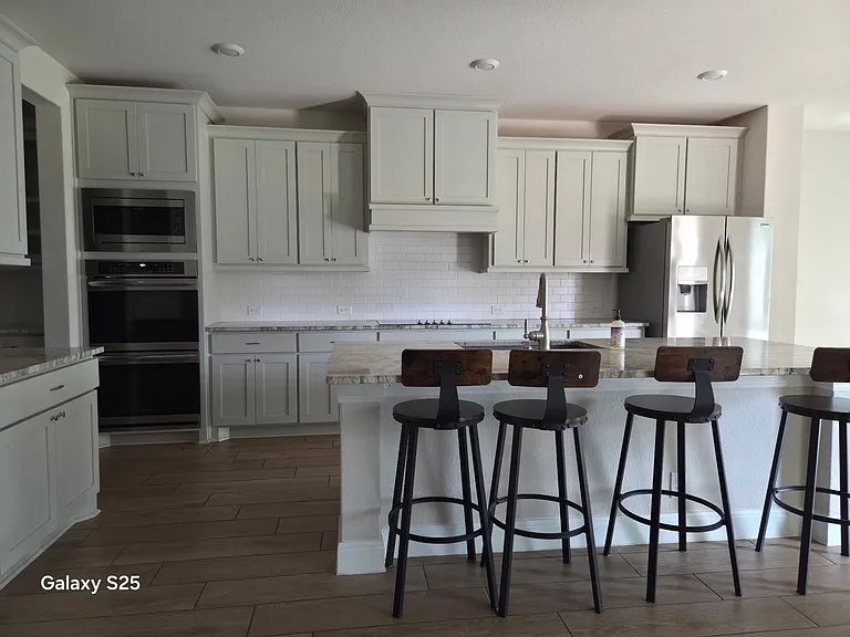 Spacious kitchen with a large island breakfast bar, ample cabinetry, and stainless-steel appliances for everyday cooking.