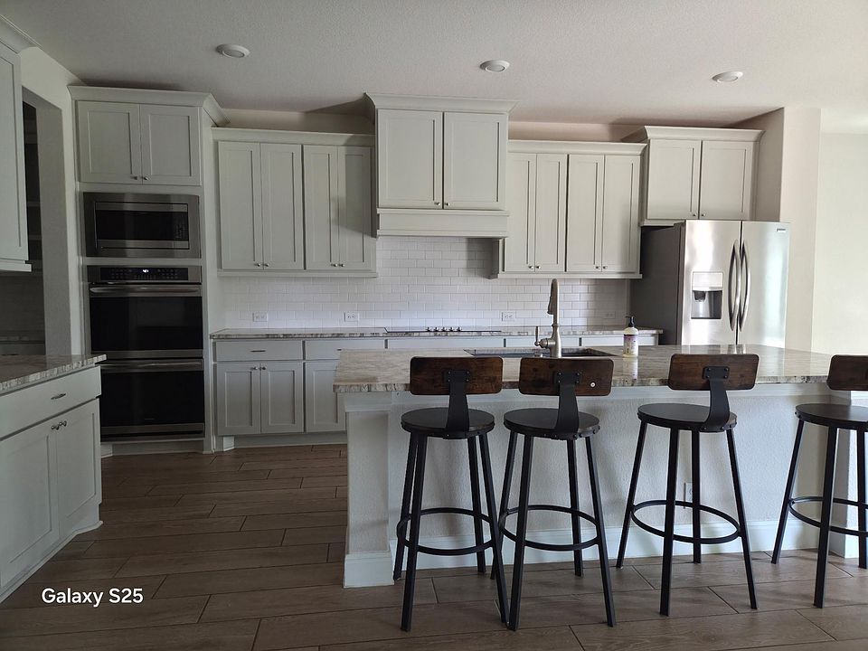 Spacious kitchen with a large island breakfast bar, ample cabinetry, and stainless-steel appliances for everyday cooking.