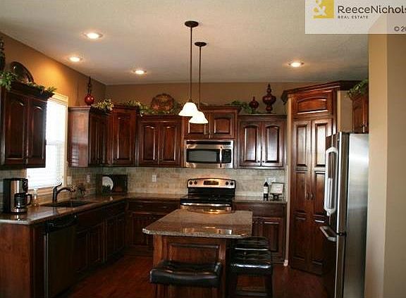 Kitchen island features seating and trash drawer.  Beautiful stained cabinets.