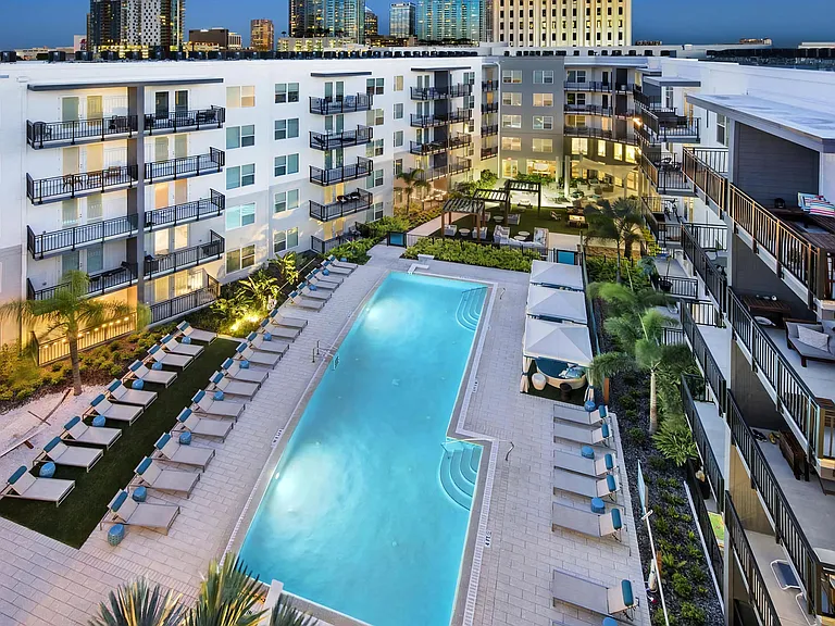Aerial Poolside Scene with City Skyline Views and Illuminated Courtyard