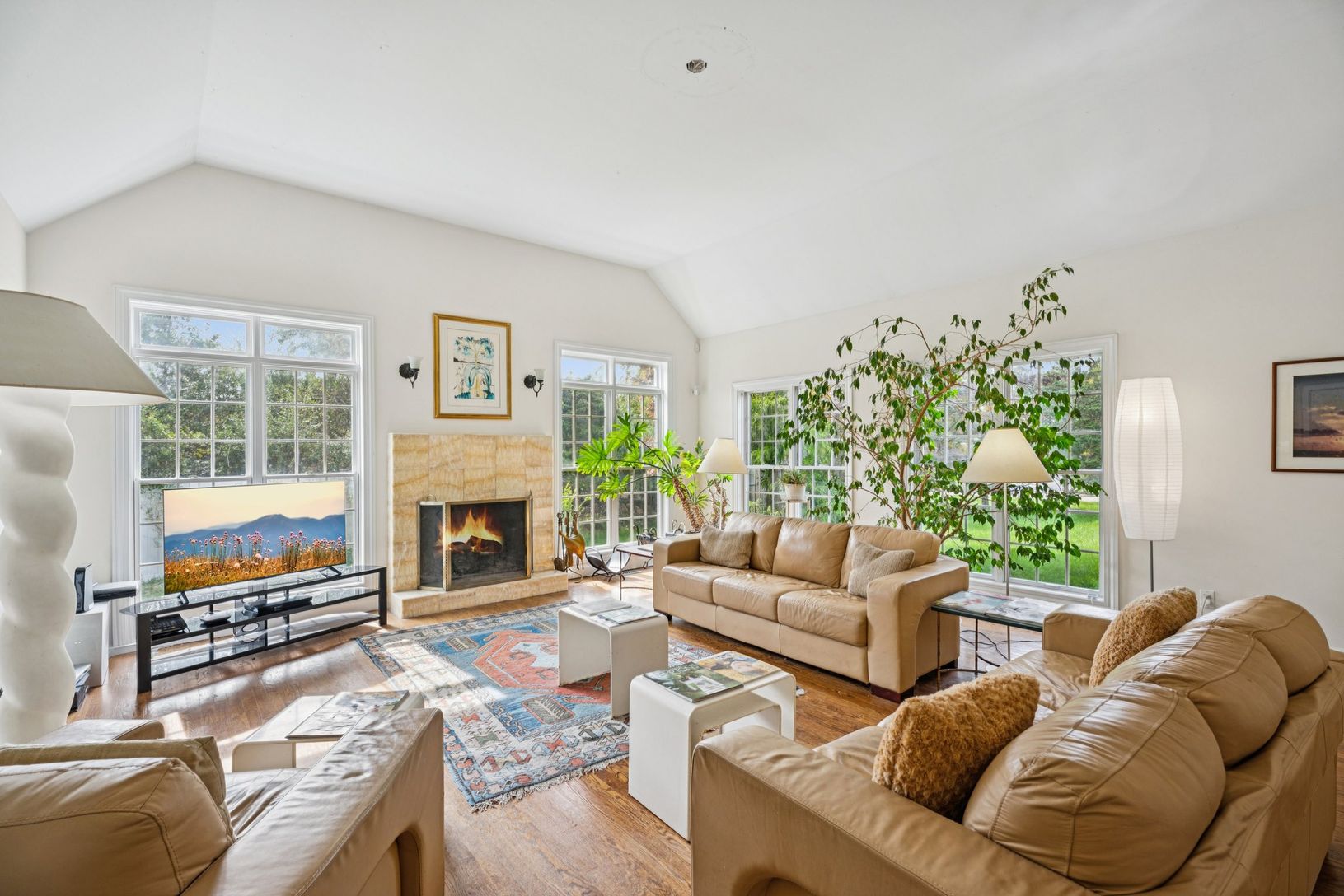 An exquisite living area showcasing vaulted ceilings, rich oak hardwood floors, and a timeless wood-