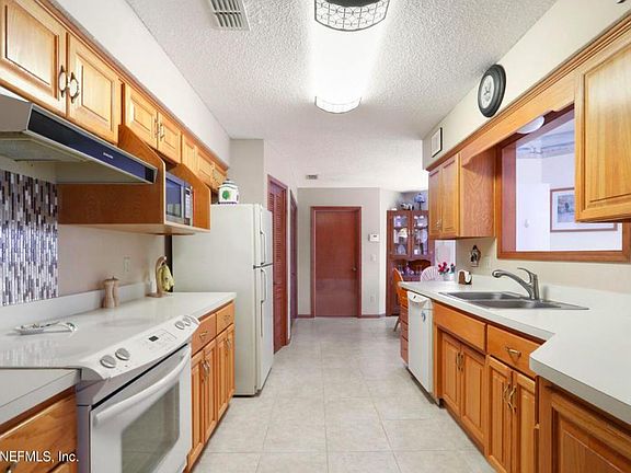 Galley Style Kitchen leading to garage passage Door