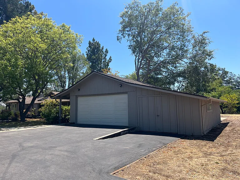 Detached two-car garage features a convenient restroom with a utility sink, walk-in storage closet and automatic door opener. A large creative workshop space is connected to the garage.