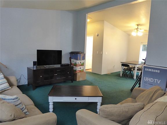 View from near the front door of living room into dining area and conveniently located door to main bathroom. 