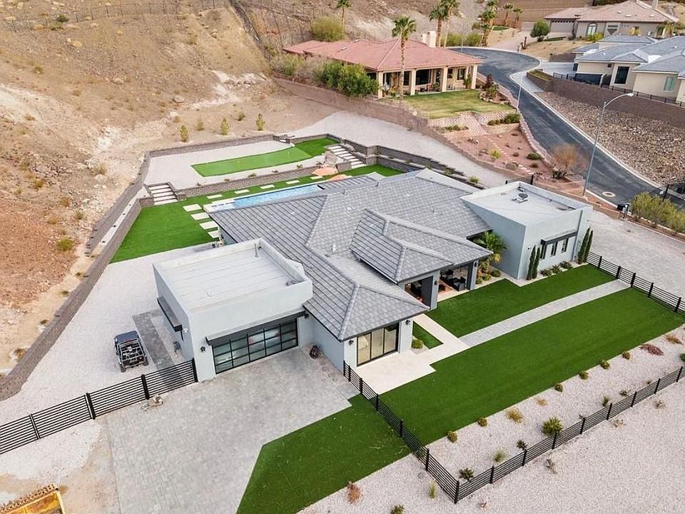 Located on 1.5 acres, custom pool & hot tub, putting green and fully fenced backyard to the top of the hill.