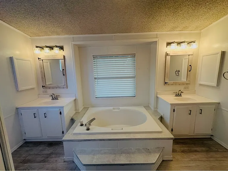 Master bath with 2 sinks, bathtub, shower, toilet and 9 large storage cabiniets.