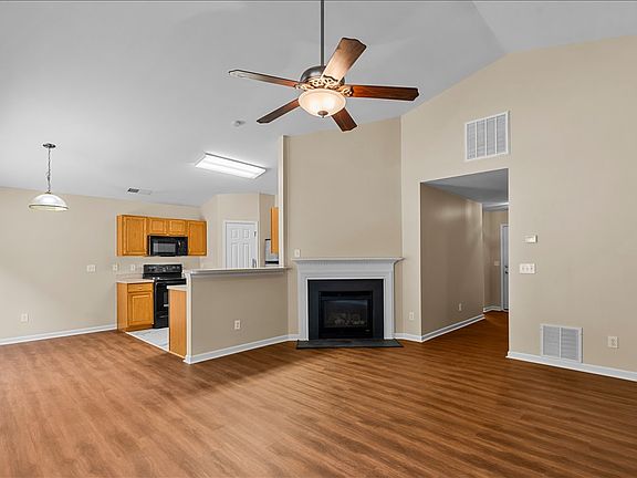 Living and dining area with gas log fireplace and vaulted ceilings