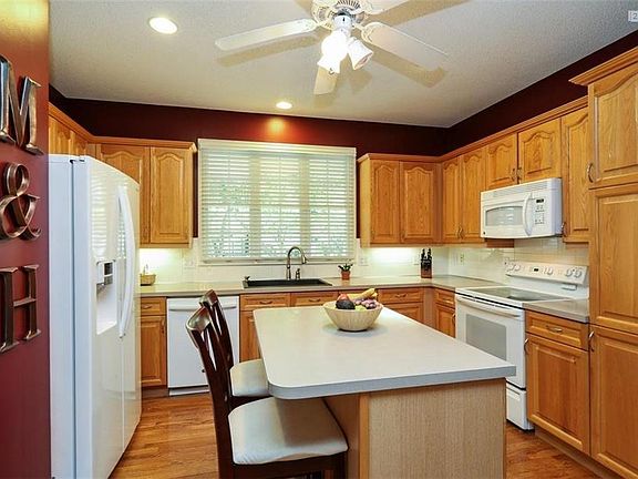 Breakfast island in kitchen and all white appliances.  Plenty of storage and counter space.