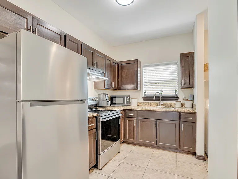 Stylish kitchen showcasing stainless steel appliances and wooden cabinetry at La Joya Apartments in Laredo, Texas