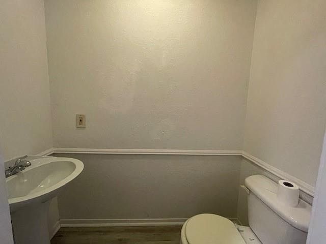 Bathroom featuring toilet and wood finished floors