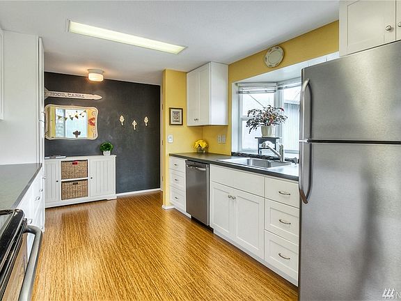 Virew of the kitchen with a garden window and entry way.