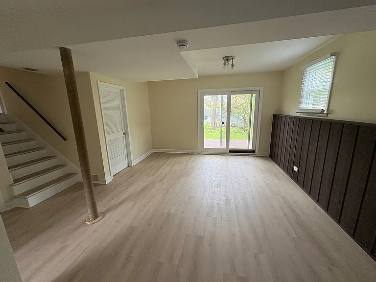 Full view of spacious, natural-light-filled living space with sliding door to back deck and back yard