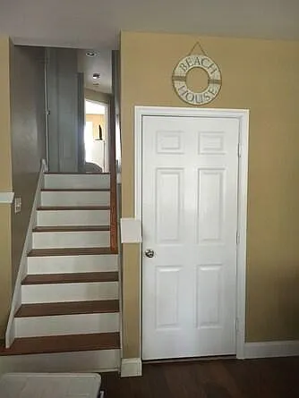 Door to garage and outdoor shower and stairs to bedrooms