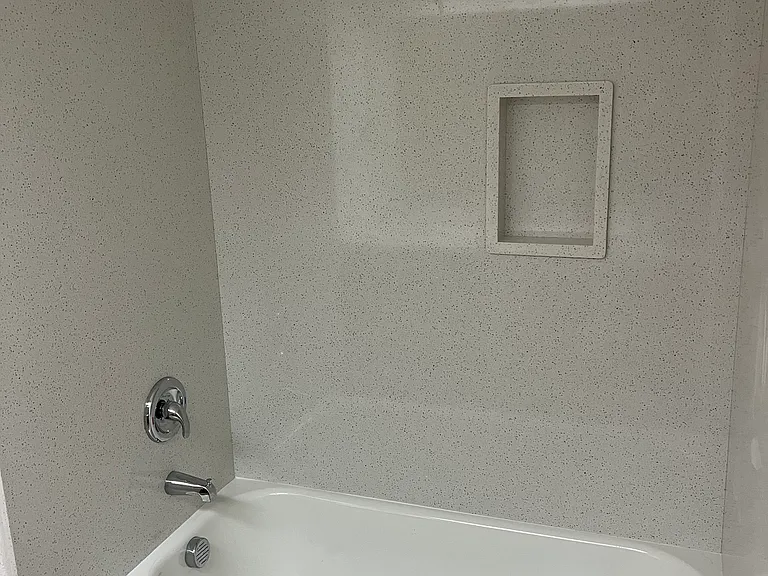 Brand new tub with quartz surround walls. Guest bathroom
