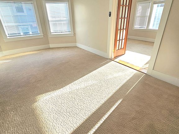 Living room with large bay windows (and view of Bedroom #1)