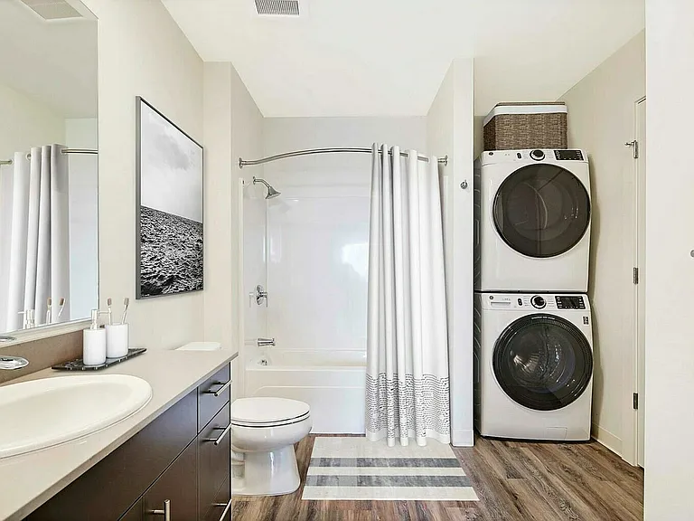 Experience convenience and style in this elegantly designed bathroom with integrated laundry.