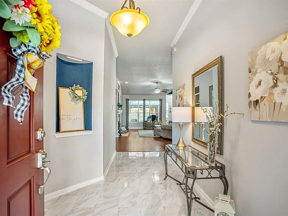Without further ado, let's go inside! The foyer is a great start to the many updates found throughout the home. The outdated tile was replaced with a modern & sleek carrera tile in 2021! Straight ahead is a peek at the living room.