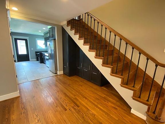 Custom built-in storage under the stairs with pull out drawers and shelves