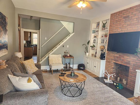 Exposed brick flanked with full-wall bookshelves in entry-way living space