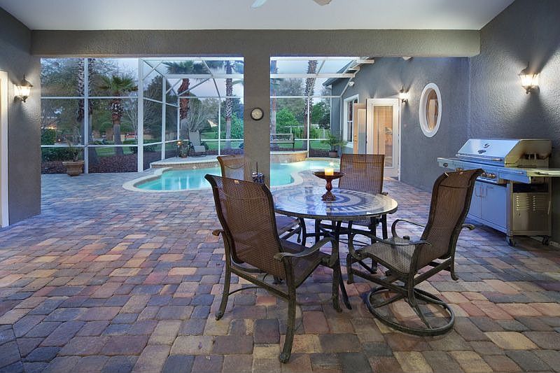 Loads of covered pool lanai space with brick pavers.