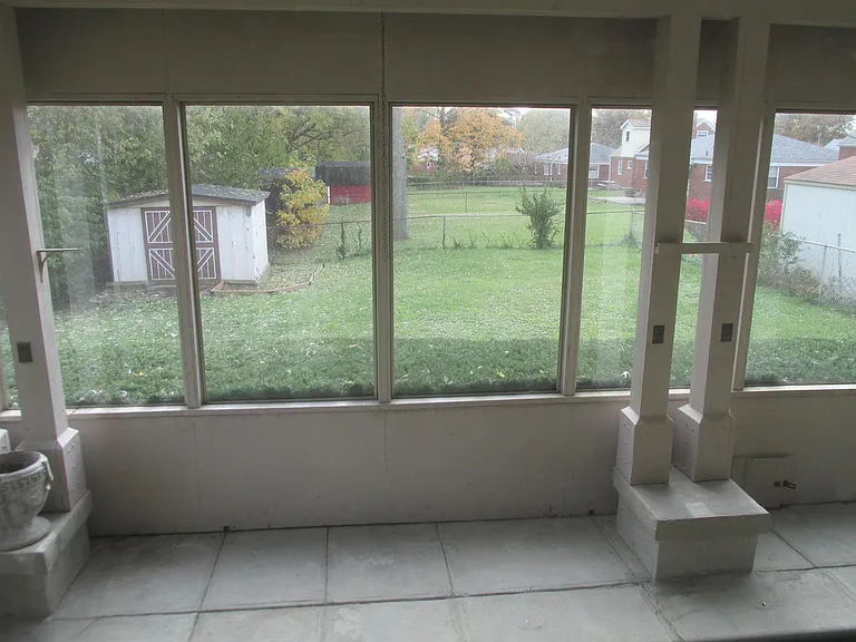 View from 3 season room of Fenced back yard. Storage Shed.