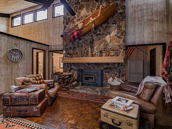 Impressive vaulted ceiling with real wood canoe above the cozy wood burning fireplace.