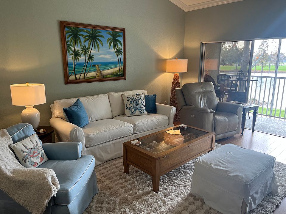 Living room with sliders to screened porch with amazing view of lake and golf course