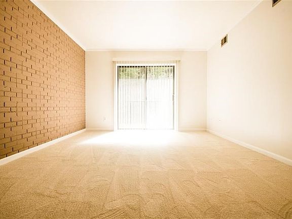 Spacious and bright living room with slider to private deck.  Newly painted and accented with brick side wall and new trim throu