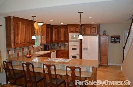kitchen with low bar
						:
						Cambria quartz counter top/tiled backsplash custom all-wood cabinets, tile floor