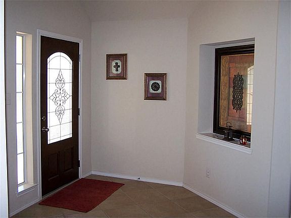 Leaded glass mahogany front door opens to foyer with accent art niche.
