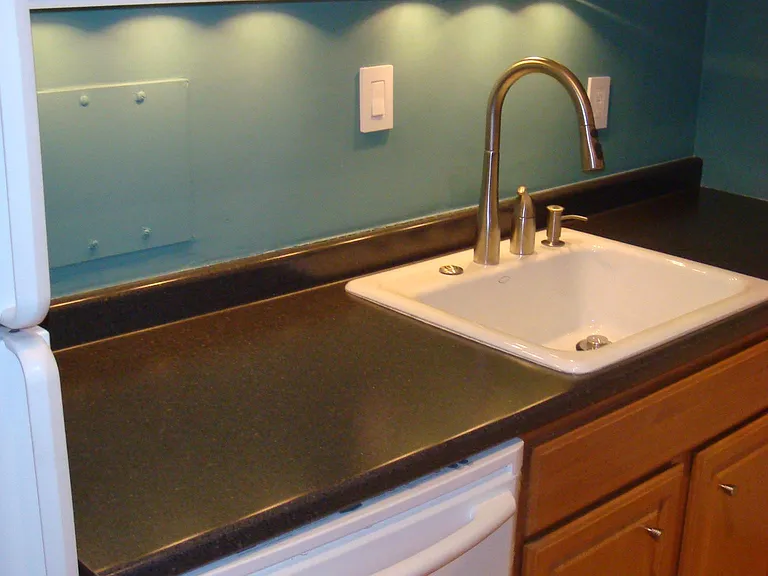 Kitchen also features under cabinet lighting, Kohler cast iron enameled sink, and garbage disposal.