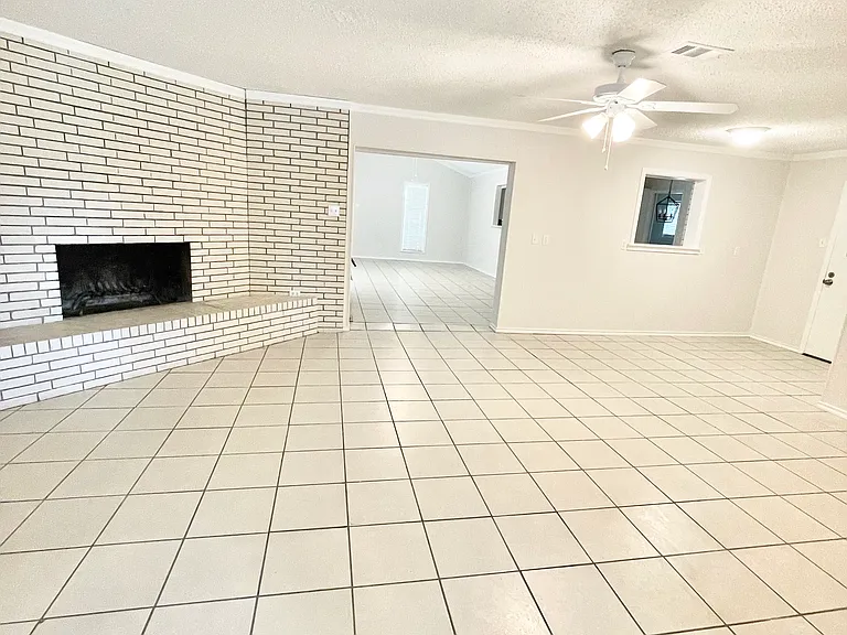 View of two large living areas and wood burning fireplace from the inside the front door