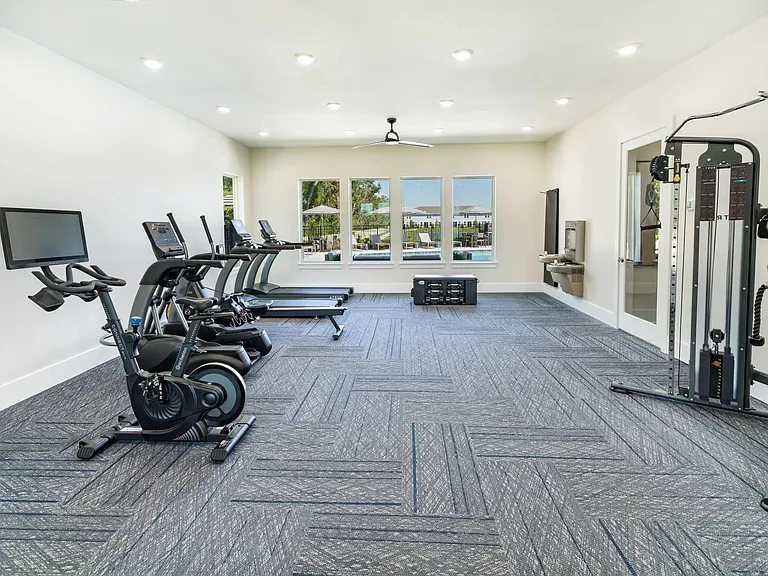 A bright, well-equipped fitness center at Amavi Kissimmee offers space to recharge, with views of the pool and everything you need for a balanced routine.