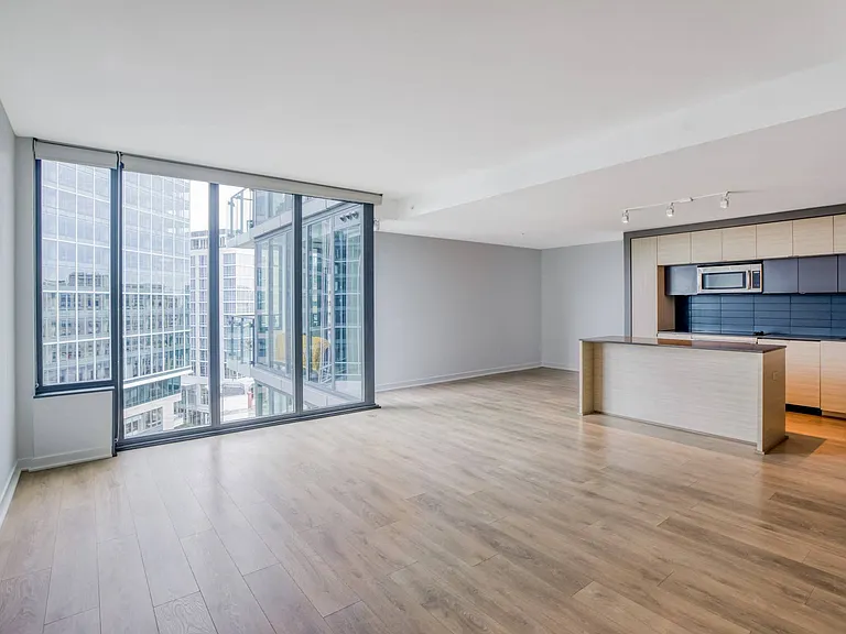 Open concept living and dining area with floor to ceiling windows