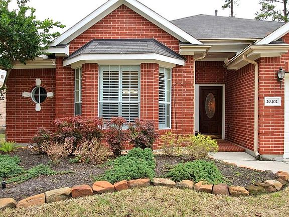 Mature landscaping surrounds the walkway to the Covered Front Porch.
