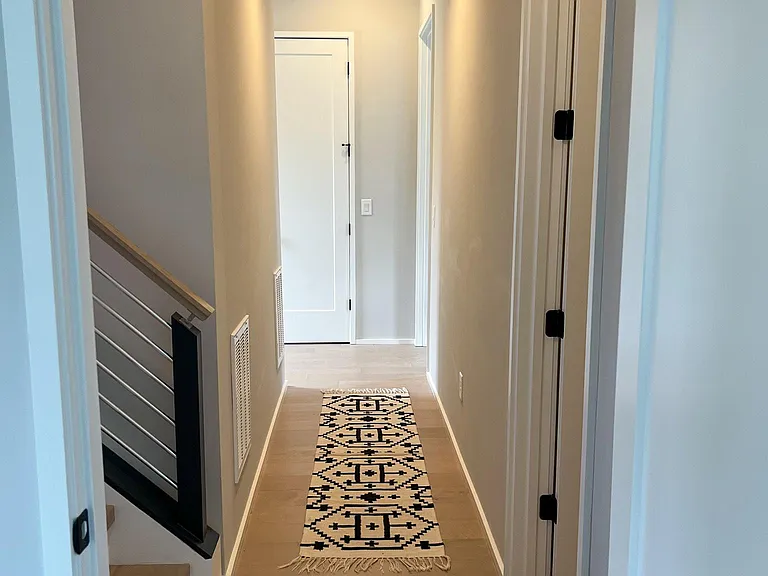Hallway between the master bedrooms - the stairway to the left takes you to the rooftop and the door on the right is a half bath