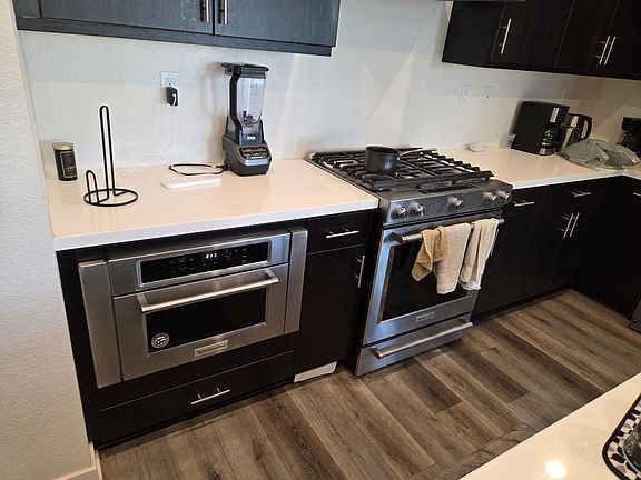 Stainless steel appliances, white counter tops.