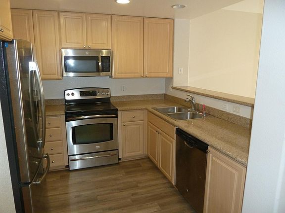Granite counters, Stainless steel appliances & luxury vinyl plank flooring in kitchen